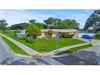 Charming single-story home featuring a well-manicured lawn and mature landscaping at 8210 68Th N Way, Pinellas Park, FL 33781