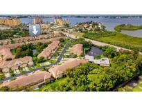 An aerial view of a residential community with mature landscaping and views of a body of water at 11246 Kapok Grand Cir, Madeira Beach, FL 33708