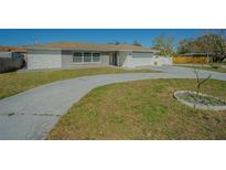 Charming single-story home featuring a well-maintained lawn and curved driveway for added curb appeal at 1760 Sharondale Dr, Clearwater, FL 33755