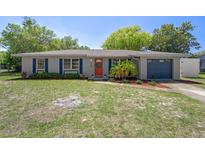 Charming single-story home featuring a well-maintained lawn, a bright orange front door, and a single car garage at 6268 Harcross Ct, Spring Hill, FL 34606