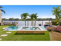Beautiful backyard pool and spa with waterfront views, surrounded by lush landscaping at 927 Anchorage Rd, Tampa, FL 33602