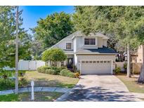 Charming two-story home featuring a well-manicured lawn, mature trees, and a two-car garage at 11386 Churchhill Trl, Seminole, FL 33772