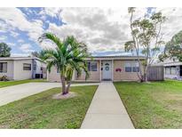 Charming home with a well-manicured lawn, a palm tree, and a welcoming walkway leading to the front door at 1142 56Th N Ave, St Petersburg, FL 33703