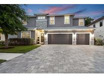 Stunning two-story home with a three-car garage and beautiful stone accents, complemented by a paver driveway at 12707 Green Heron Way, Odessa, FL 33556