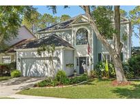 Charming two-story home features a well-manicured lawn, lush landscaping, and an attached two-car garage at 17712 Long Ridge Rd, Tampa, FL 33647