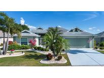 Charming single-story home with a well-manicured lawn, lush landscaping, and an attached two-car garage at 2217 W Del Webb Blvd, Sun City Center, FL 33573