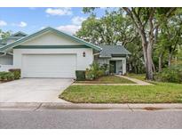 Charming single Gathering home with a well-manicured lawn and attached garage at 235 Woodridge Cir, Oldsmar, FL 34677