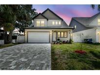 Charming two-story home with a well-manicured lawn and paver driveway at 3106 W Cherokee Ave, Tampa, FL 33611