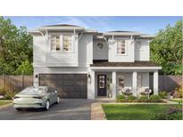 Charming two-story home featuring a two-car garage, inviting front porch, and manicured lawn at 3303 W Tambay Ave, Tampa, FL 33611