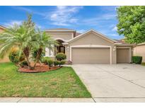 Charming tan home with well-manicured front yard, featuring a two-car garage and inviting curb appeal at 3510 Hickory Hammock Loop, Wesley Chapel, FL 33544