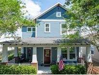 Charming two-story home with blue siding, white trim, covered front porch, and landscaped front yard at 6015 Shell Ridge Dr, Lithia, FL 33547