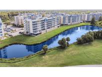 Aerial view of a condo community surrounding a pond with a fountain and well-manicured landscaping at 960 Starkey Rd # 7202, Largo, FL 33771