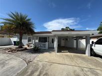 Charming single story home features a carport, palm tree, and an inviting front porch at 2117 W Clifton St, Tampa, FL 33603
