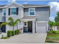 Charming two-story townhome featuring a well-maintained lawn, one-car garage, and welcoming front entrance at 2882 Suncoast Plains Dr, Odessa, FL 33556