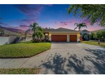 Charming home featuring a well-manicured lawn, mature landscaping, and a two-car garage, perfect for curb appeal at 9504 Laurel Ledge Dr, Riverview, FL 33569