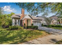 Charming single-Gathering home featuring brick accents, manicured landscaping, and a two-car garage at 11611 Meridian Point Dr, Tampa, FL 33626