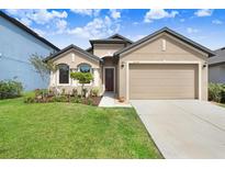 Charming single-Gathering home features a manicured lawn, two-car garage, and neutral-tone exterior at 1214 Florablu Dr, Seffner, FL 33584