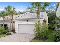 Charming home with a two-car garage, brick-paved driveway, and beautiful landscaping with palm trees at 16030 Bella Woods Dr, Tampa, FL 33647