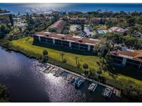 An aerial shot reveals a waterfront condo complex with docks and a pool, offering scenic views at 1686 Seascape Cir, Tarpon Springs, FL 34689