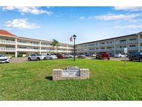A condominium complex with well-manicured green lawn and visible signage out front at 2452 Brazilia Dr # 32, Clearwater, FL 33763