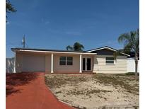 Charming single-story home featuring a red driveway, covered porch and attached garage at 3301 Clydesdale Dr, Holiday, FL 34691