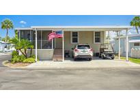 Charming single-story home with covered parking, landscaping, and an American flag at 4851 W Gandy Blvd # B09L23, Tampa, FL 33611