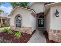 Front entrance featuring arched window and brick accents, leading to a welcoming front door at 6711 Thackston Dr, Riverview, FL 33578
