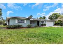 Charming single story home with a well-maintained lawn and attached garage under a cloudy blue sky at 1881 Stancel Dr, Clearwater, FL 33764