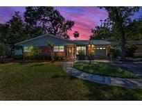 Charming brick home featuring manicured lawn, sidewalk, and meticulous landscaping creates a welcoming curb appeal at 202 S Hesperides St, Tampa, FL 33609