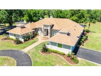 Stunning single-story home with a beautifully landscaped yard, circular driveway, and grand entrance at 30723 Reed Rd, Dade City, FL 33523