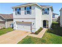 Charming two-story home featuring a neutral color scheme, attached garage, and well-maintained lawn at 32721 Brooks Hawk Ln, Wesley Chapel, FL 33543