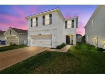 Charming two-story home features a two car garage and a well maintained lawn in a suburban neighborhood at 32721 Brooks Hawk Ln, Wesley Chapel, FL 33543