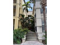 Inviting entrance with lush tropical landscaping and walkway to the building's front door at 402 S Armenia Ave # 127, Tampa, FL 33609