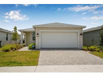 Charming single-story home featuring a two-car garage, manicured lawn, and welcoming facade at 44239 Frontier Dr, Punta Gorda, FL 33982
