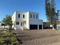 Modern two-story home featuring a clean, minimalist design with a two-car garage at 4716 W Lawn Ave, Tampa, FL 33611