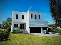 New construction featuring clean lines, a modern design, and a two-car garage at 4716 W Lawn Ave, Tampa, FL 33611