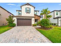 Charming two-story house featuring a paved driveway, two-car garage, and well-manicured lawn at 4784 San Martino Dr, Wesley Chapel, FL 33543