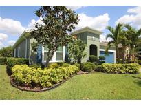 Beautiful home with lush landscaping, vibrant plants, and a well-manicured lawn creating inviting curb appeal at 6417 Blue Sail Ln, Apollo Beach, FL 33572