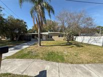 Charming single-story home with a well-manicured lawn and a palm tree in the front yard at 7366 Royal Palm Dr, New Port Richey, FL 34652