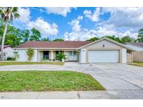 Charming single-story home with a well-manicured lawn and a classic brick and siding exterior at 8513 Sunflower Ln, Hudson, FL 34667