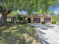 Charming single-story home with a three car garage and mature landscaping at 11383 Pickford St, Spring Hill, FL 34609