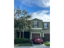View of the two-story townhouse with a well-maintained lawn and a parked car out front at 1438 Mallory Sail Pl, Brandon, FL 33511