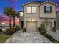 Inviting two-story home with a two-car garage, paved driveway, and well-manicured landscaping at 19153 Elsimont Isle, Lutz, FL 33558