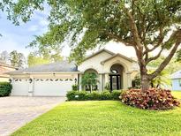 Charming single-story home featuring a three-car garage, well-manicured lawn and attractive landscaping at 21422 Draycott Way, Land O Lakes, FL 34637