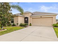 Charming single-story home features a well-maintained lawn, mature trees, and a two-car garage at 233 Cascade Bend Dr, Ruskin, FL 33570