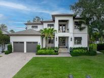 Stunning two-story home with a well-manicured lawn, palm trees, and a spacious three-car garage at 2501 S Dundee St, Tampa, FL 33629