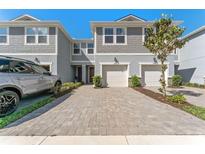 Beautiful townhome with a well-manicured front yard and a two-car driveway and garage at 2525 Arbor Wind Dr, Lutz, FL 33558