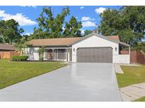 Charming single-story home featuring a large two-car garage and well-maintained landscaping at 2719 Cypress Hollow Ct, New Port Richey, FL 34655