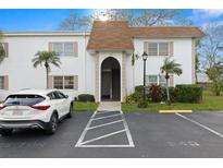 White condo building exterior with neat landscaping, parking, and brown roof at 343 S Mcmullen Booth Rd # 151, Clearwater, FL 33759