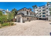 Stunning exterior view with brick drive, manicured landscape, and attached garage of a modern luxury home at 455 Pinellas Bayway S # 2B, Tierra Verde, FL 33715